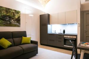 卡萨莱蒙费拉托Mameli Comfort的带沙发的客厅和厨房