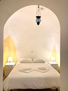 Perales de TajuñaCasa Cueva Castillo的一间卧室配有白色床和2个床头柜