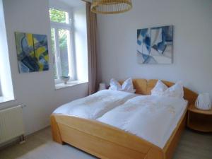 WünschendorfApartment in a villa with garden in Borstendorf的卧室配有一张带白色床单和枕头的大床。