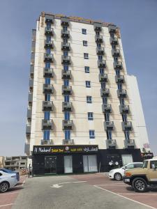 马斯喀特Al Dhiyafa Palace Hotel Apartments قصر الضيافة للشقق الفندقية的一座高大的白色建筑,汽车停在停车场