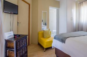 勒斯滕堡Seroloana Guest House的一间卧室配有一张床和一张黄色椅子