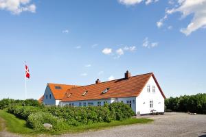 约灵Klitgaarden的一座白色的大建筑,有橙色的屋顶