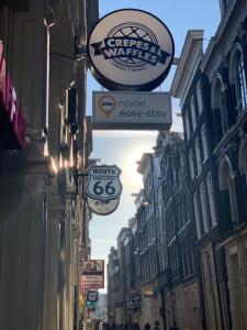 阿姆斯特丹Hostel Warmoes Amsterdam的建筑物一侧有标志的街道