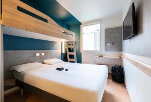 兰斯兰斯蒂卢瓦宜必思快捷酒店的卧室配有一张白色大床和电视。