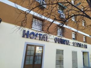 埃纳雷斯河畔圣费尔南多Hostal Quinta Santillan的建筑的侧面有标志