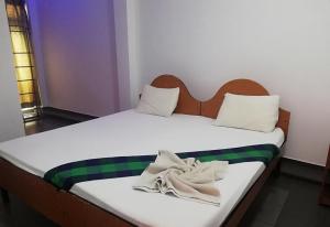 亭可马里Sunshine Hotel的一间卧室配有两张带毛巾的床