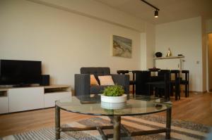 克诺克－海斯特appartement DE WATERLIJN的客厅配有玻璃桌和电视