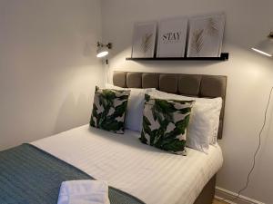 圣海伦斯Womack Lodge的一间卧室配有带白色床单和绿色枕头的床。