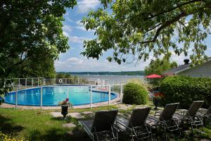 Saint-Laurent-de-l'ile d'OrleansGoéliche hotel et appartement的一个带椅子的游泳池,享有水景