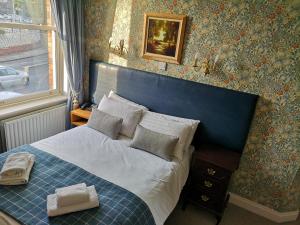 邓多克格伦加特之家旅馆的卧室里一张带蓝色床头板的床