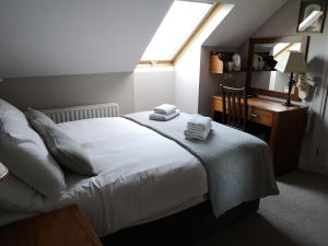 邓多克格伦加特之家旅馆的一间卧室配有一张床、一张书桌和一个窗户。