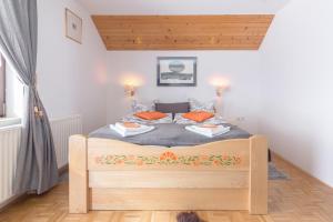博希尼Apartments Ukanc的一间卧室配有带橙色枕头的木床