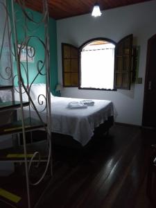 圣安东尼奥-杜皮尼亚尔Pousada Venezia的一间卧室配有一张带白色床罩的床和窗户。