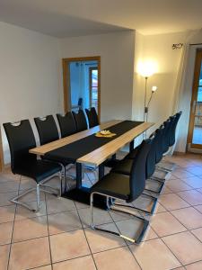 翁特拉梅尔高Ferienwohnung mit Bergblick的用餐室配有木桌和黑椅子