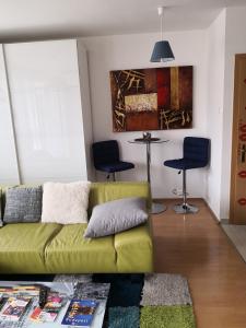 布达佩斯1,5 szobás lakás terasszal,közel a Széchenyi fürdőhöz的客厅配有绿色沙发和两把椅子