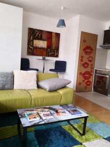 布达佩斯1,5 szobás lakás terasszal,közel a Széchenyi fürdőhöz的客厅配有绿色沙发和桌子