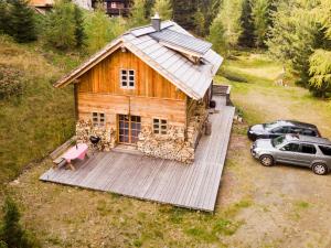 博登斯多夫Almhütte Chalet HIRSCHFISCH的享有木屋和汽车的空中景致