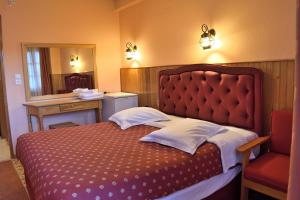 美特索文麦索福酒店的一间卧室配有一张带红色床头板和镜子的床