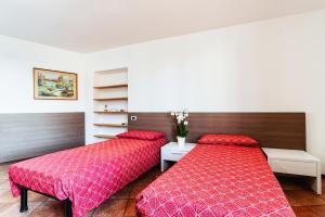 卢奇诺Il Roseto di Marina的红色床单的客房内的两张床