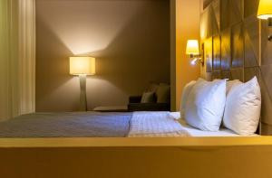 莱昂格罗蓬特酒店 - 穆尔扎的配有白色枕头的床的酒店客房