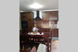 帕德隆Casa Rural A Eira Vella的厨房配有餐桌和椅子,厨房
