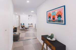 锡拉库扎New apartment with patio的客厅配有沙发和墙上的绘画