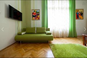 布达佩斯Spirit Nádor Ter Apartment的客厅配有绿色沙发和电视