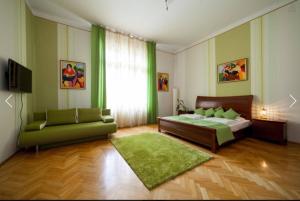 布达佩斯Spirit Nádor Ter Apartment的一间卧室配有一张床和一张绿色沙发