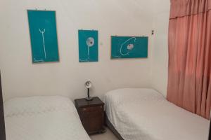 基布多Apartamento amoblado的一间卧室配有两张床,墙上有两幅画作
