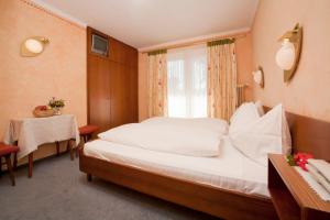 沃尔特湖畔佩莎赫圣奥斯沃德霍夫酒店的一间卧室配有一张床、一张桌子和一个窗户。