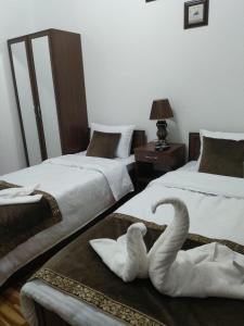 撒马尔罕Guest House Safina-S&D的一张桌子上坐着两个天鹅,房间带两张床
