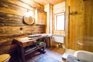 博登斯多夫Almhütte Chalet HIRSCHFISCH的木制浴室设有水槽和镜子