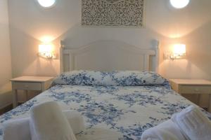 卡兰博希Chalet Cerca de la Playa的卧室配有蓝色和白色的床和两张桌子