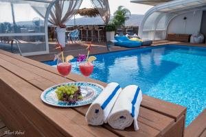 哈德内斯Yosefdream Luxury suites的游泳池旁的餐桌,包括饮料和一盘食物