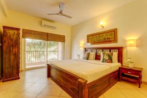 卡兰古特Heritage Nirvana Villa - 4BHK, Goa的一间卧室设有一张大床和一个窗户。