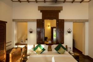 马杜赖马杜赖遗产酒店的一间卧室配有一张大床和镜子