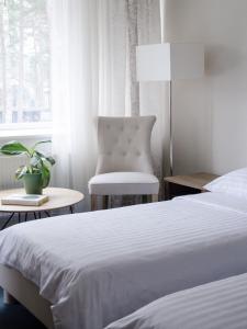 拉脱维亚Pine Resort的卧室配有床、椅子和窗户。
