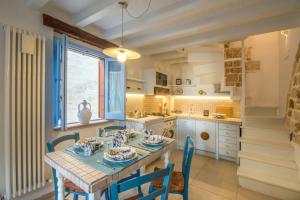 滨海波利尼亚诺Trulli&Dimore - Casa Reina的厨房配有桌椅和窗户。
