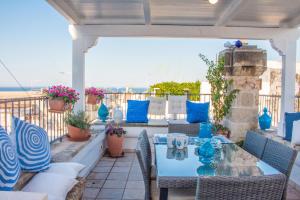 滨海波利尼亚诺Trulli&Dimore - Casa Reina的一个带桌椅的庭院和大海