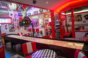 GislingeVettebar Guesthouse的餐厅设有酒吧,配有红色和白色的椅子