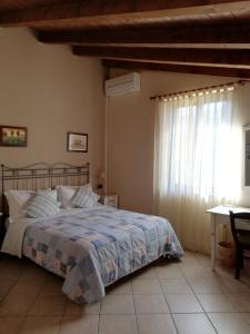 里韦尔加罗曼德罗拉农庄民宿的一间卧室配有一张床、一张桌子和一个窗户。