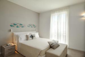 阿拉西奥Residence San Marco Suites&Apartments Alassio的卧室配有白色的床和窗户。