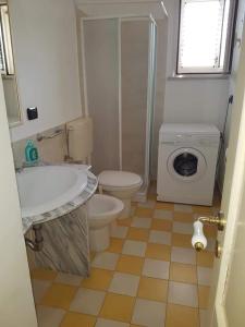 普雷西切Appartamento in Salento nel borgo di Presicce的浴室配有卫生间水槽和洗衣机。