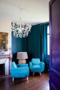 CahonLe Jardin, chambres d'hôtes en Baie de Somme的客厅配有蓝色椅子和吊灯。