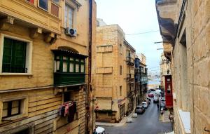瓦莱塔Valletta Lucia Townhouse的两栋建筑之间街道的景色