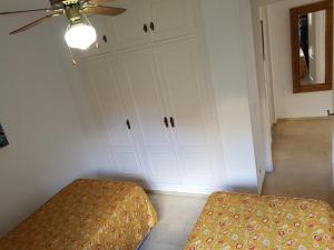卡拉德米哈斯Torreoceano H4的一间卧室配有一张床和一个带吊扇的衣柜