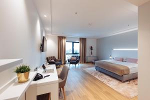 赛斯韦泰Antunović Hotel East的配有一张床和一张书桌的酒店客房