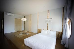 南府HOMU Villa Pua的卧室配有白色的床和窗户。