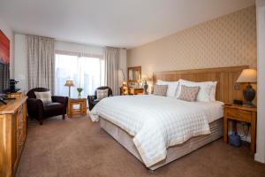 斯托诺韦广泛海湾之家酒店的卧室配有一张白色大床和一把椅子
