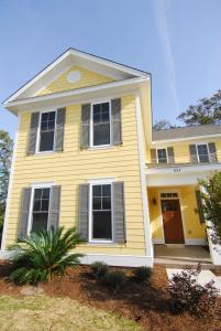 默特尔比奇The Cottages at North Beach Resort & Villas的黄色的房子,上面有黑色百叶窗